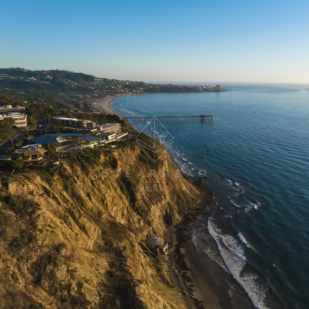 Aerial view of the cliffs, the pier and the ocean at La Jolla Shores.
