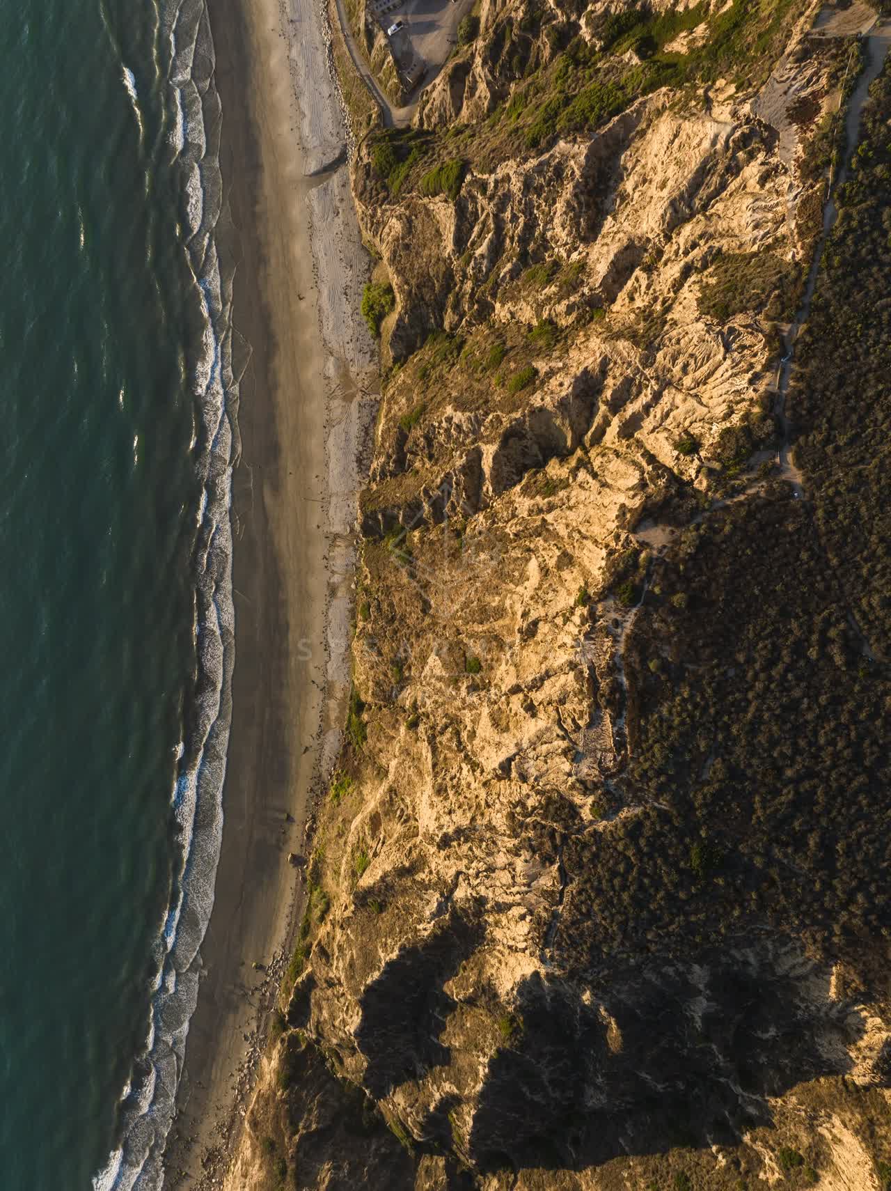 Aerial view of the cliffs, the surf and the ocean at Black’s Beach.