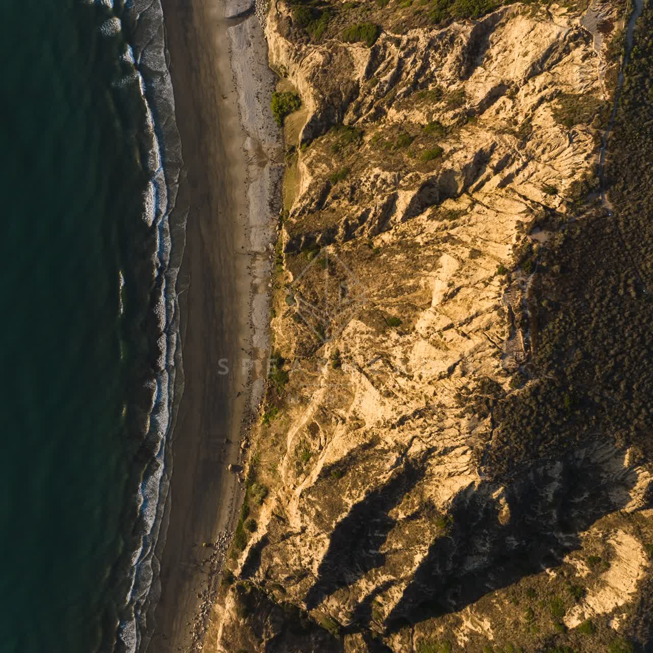 Aerial view of the cliffs, the surf and the ocean at Black’s Beach.