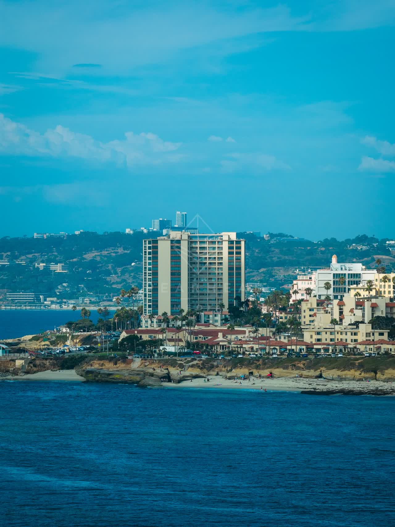 Aerial view of the beach, palm trees and the ocean at La Jolla Cove.
