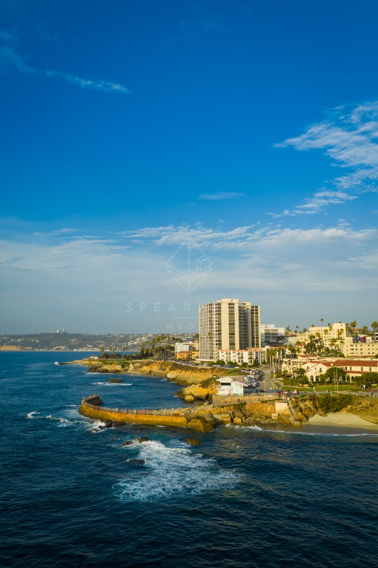 Aerial view of the cliffs, the surf and the ocean at Village of La Jolla.