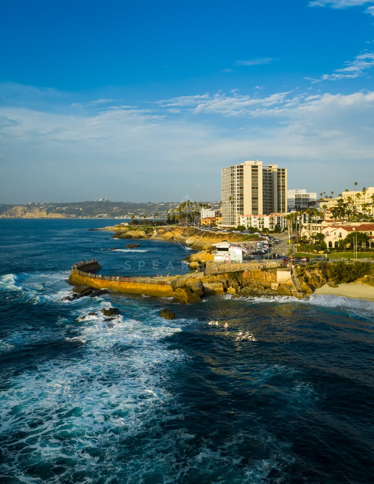 Aerial view of the cliffs, the surf and the ocean at Village of La Jolla.