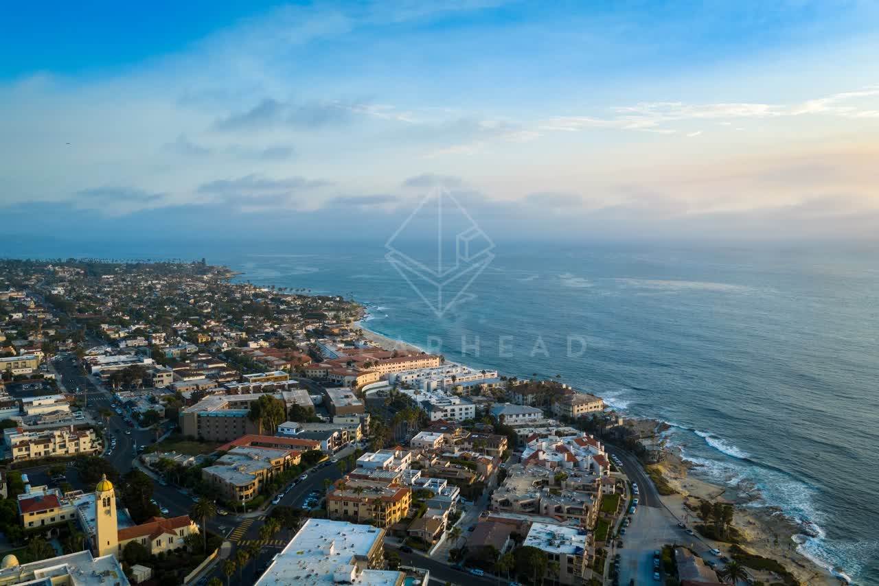 Aerial view of a residential street, palm trees and the ocean at Village of La Jolla.