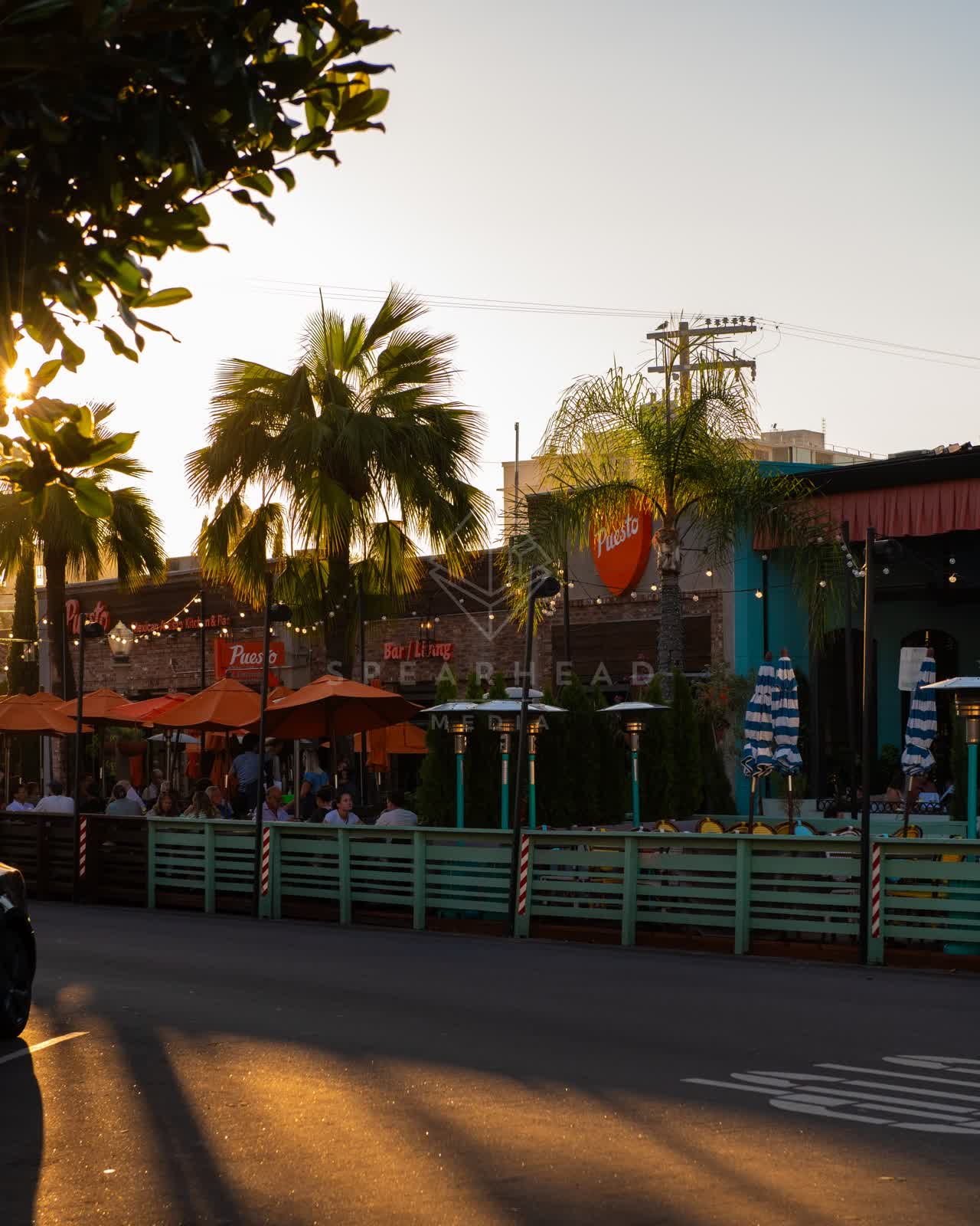 The downtown streets, palm trees and the buildings at Village of La Jolla, with people eating outside.