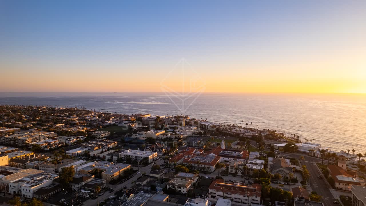 Aerial view of a residential street, palm trees and the ocean at La Jolla Cove.
