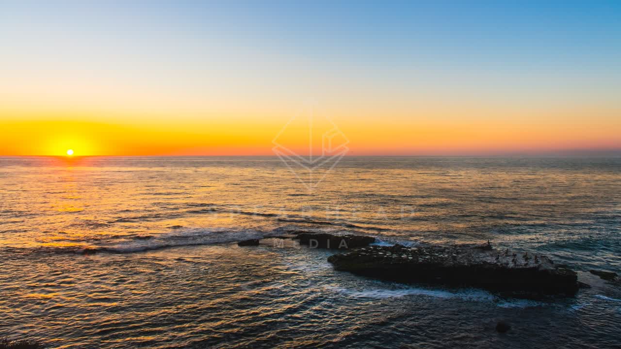 Low aerial view of the beach, the ocean and the cliffs at La Jolla Cove.