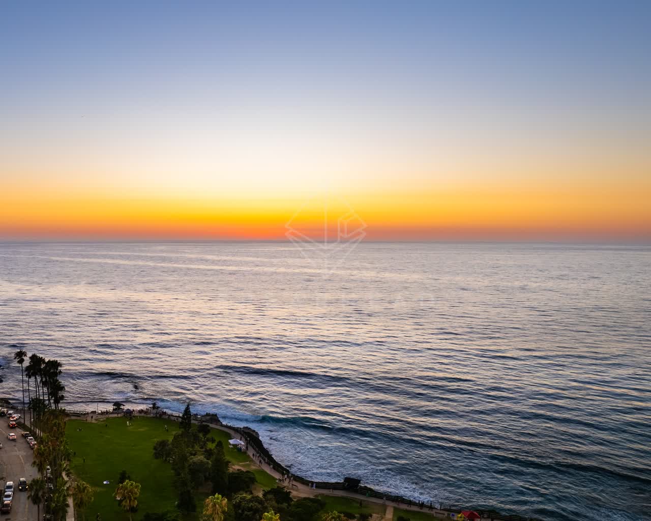 Aerial view of the cliffs, palm trees and the ocean at La Jolla Cove.