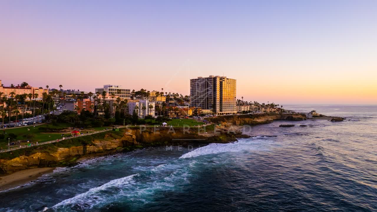 Aerial view of the cliffs, palm trees and the ocean at La Jolla Cove.