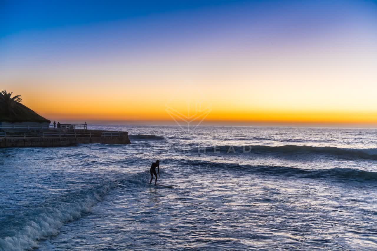 Elevated view of the beach, the surf and the ocean in Ocean Beach, with surfers out.