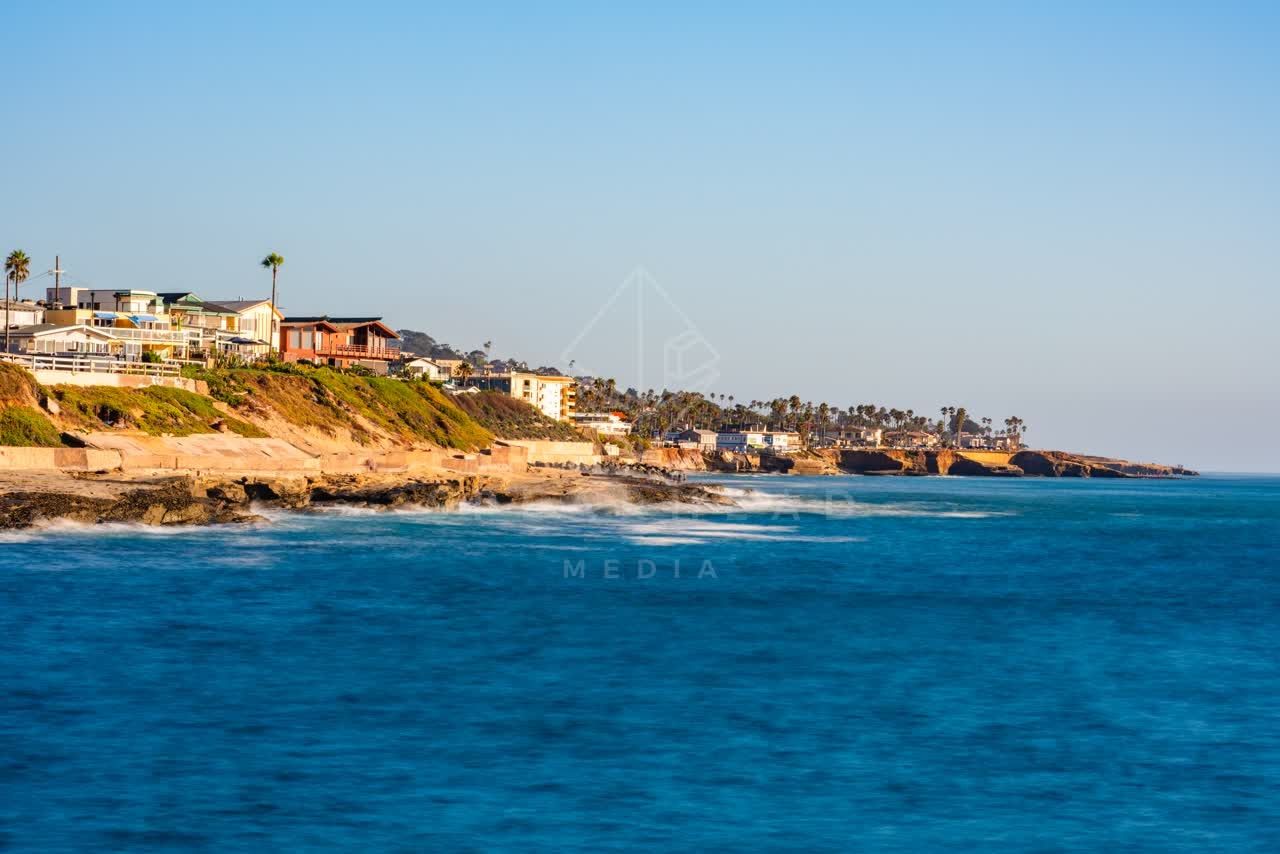 View from the water of the cliffs, the surf and palm trees in Ocean Beach.