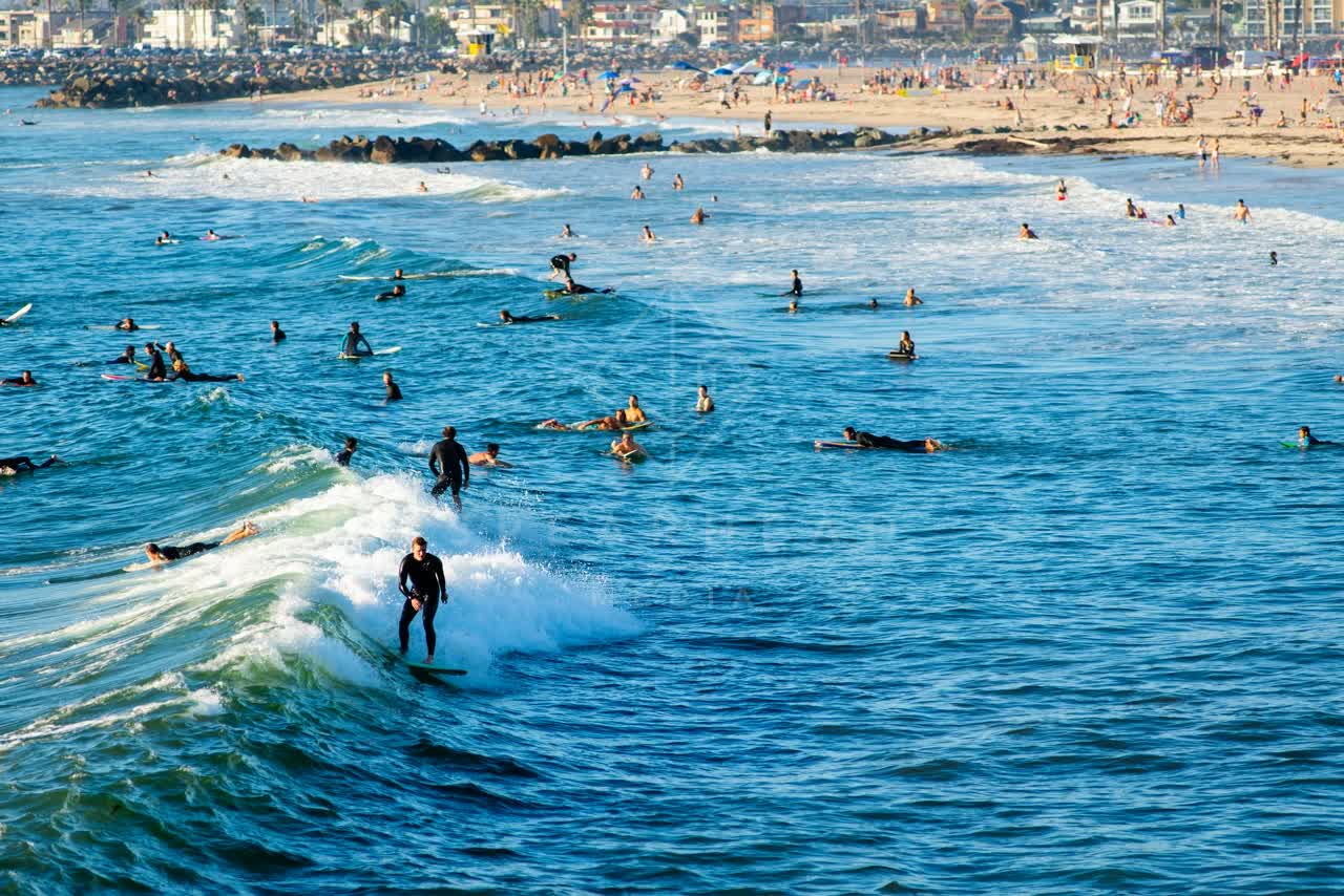Elevated view of the beach, the surf and the ocean in Ocean Beach, with surfers out.