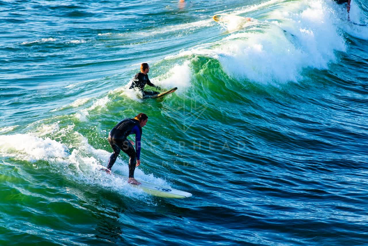 Elevated view of the beach, the surf and the ocean in Ocean Beach, with surfers out.