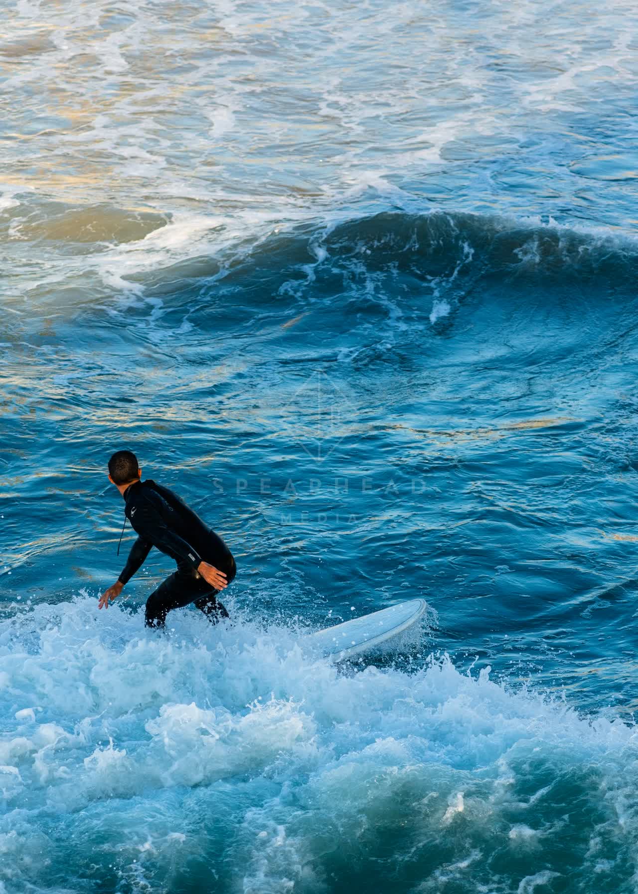 Elevated view of the beach, the surf and the ocean in Ocean Beach, with surfers out.