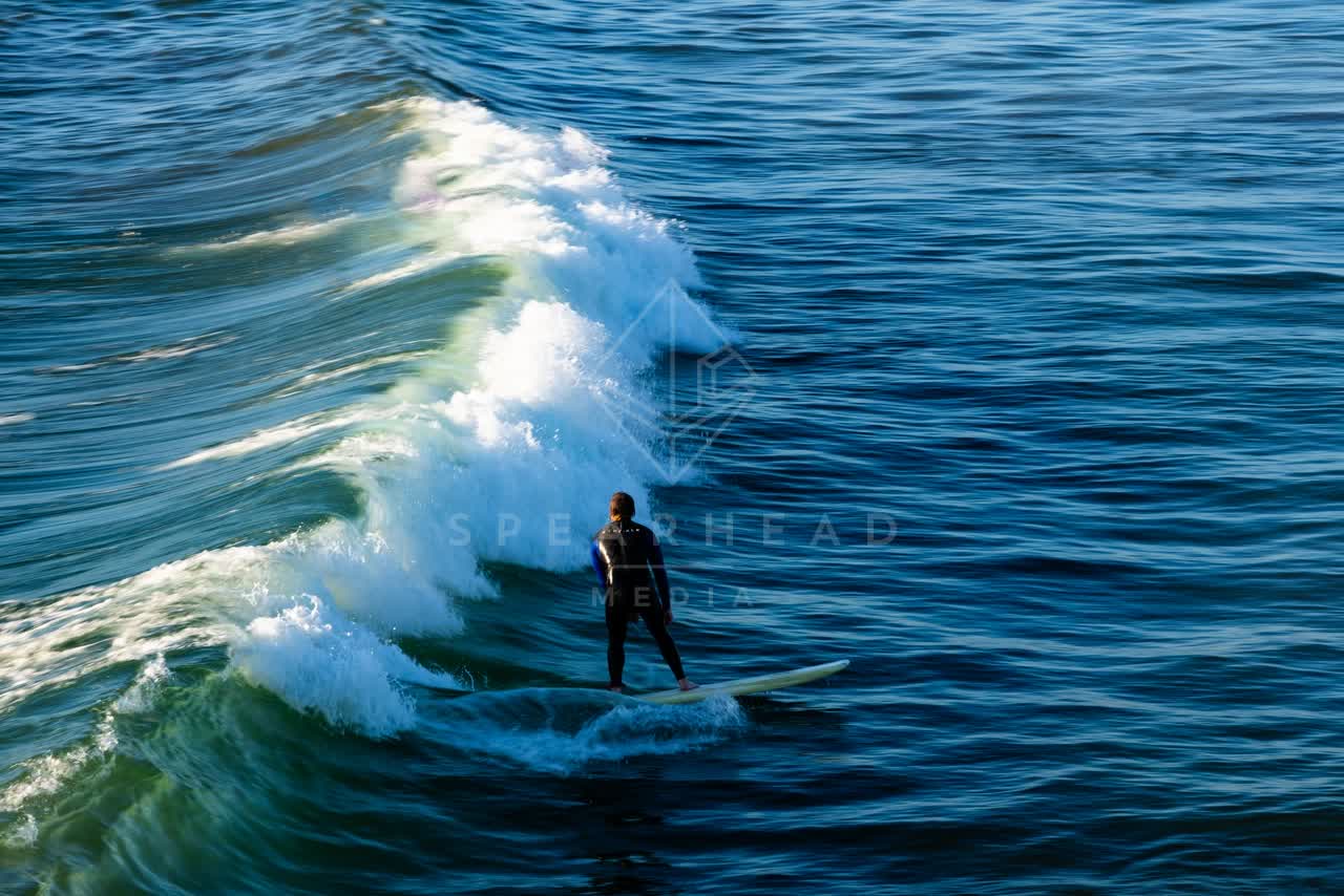 Elevated view of the beach, the surf and the ocean in Ocean Beach, with surfers out.