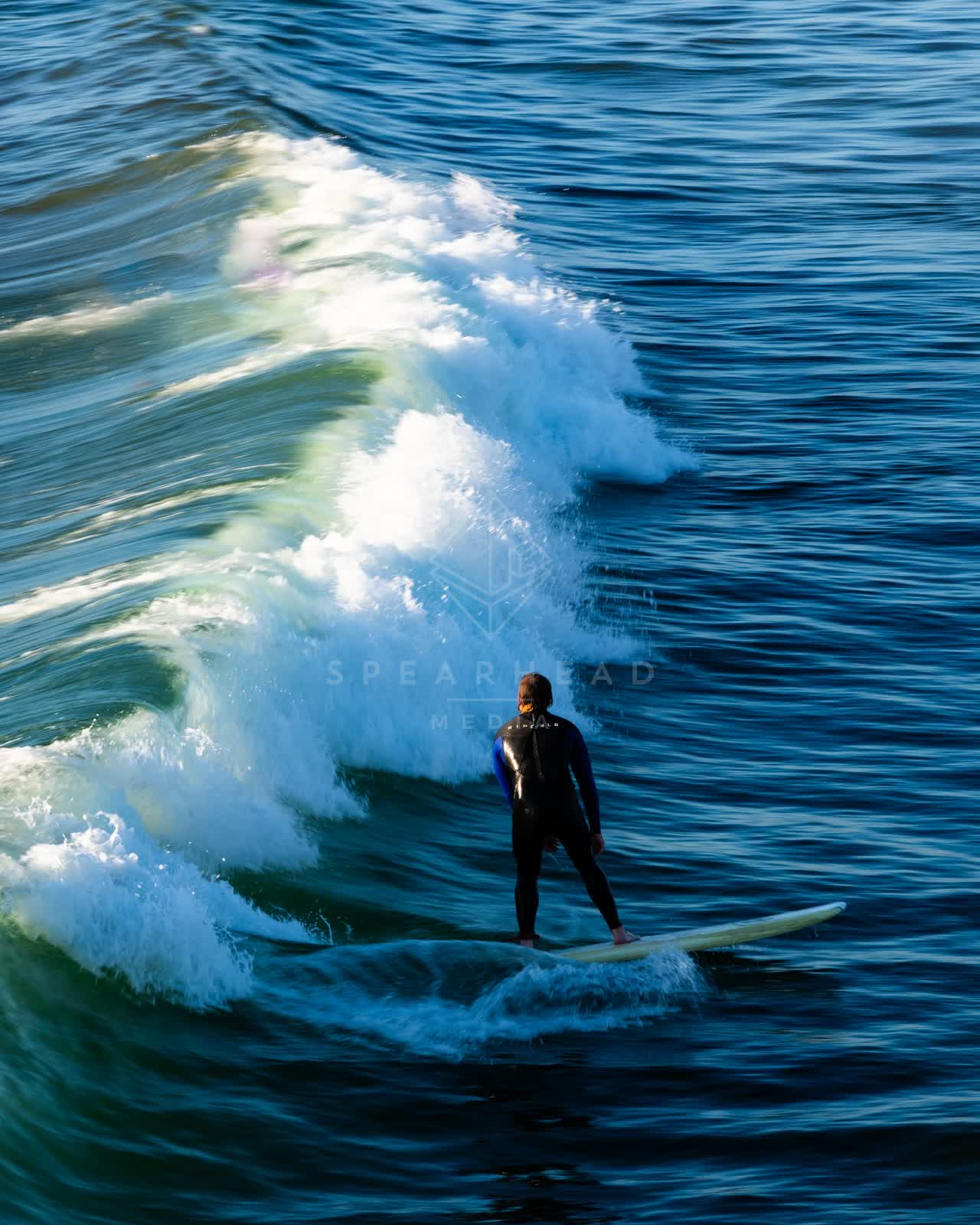 Elevated view of the beach, the surf and the ocean in Ocean Beach, with surfers out.