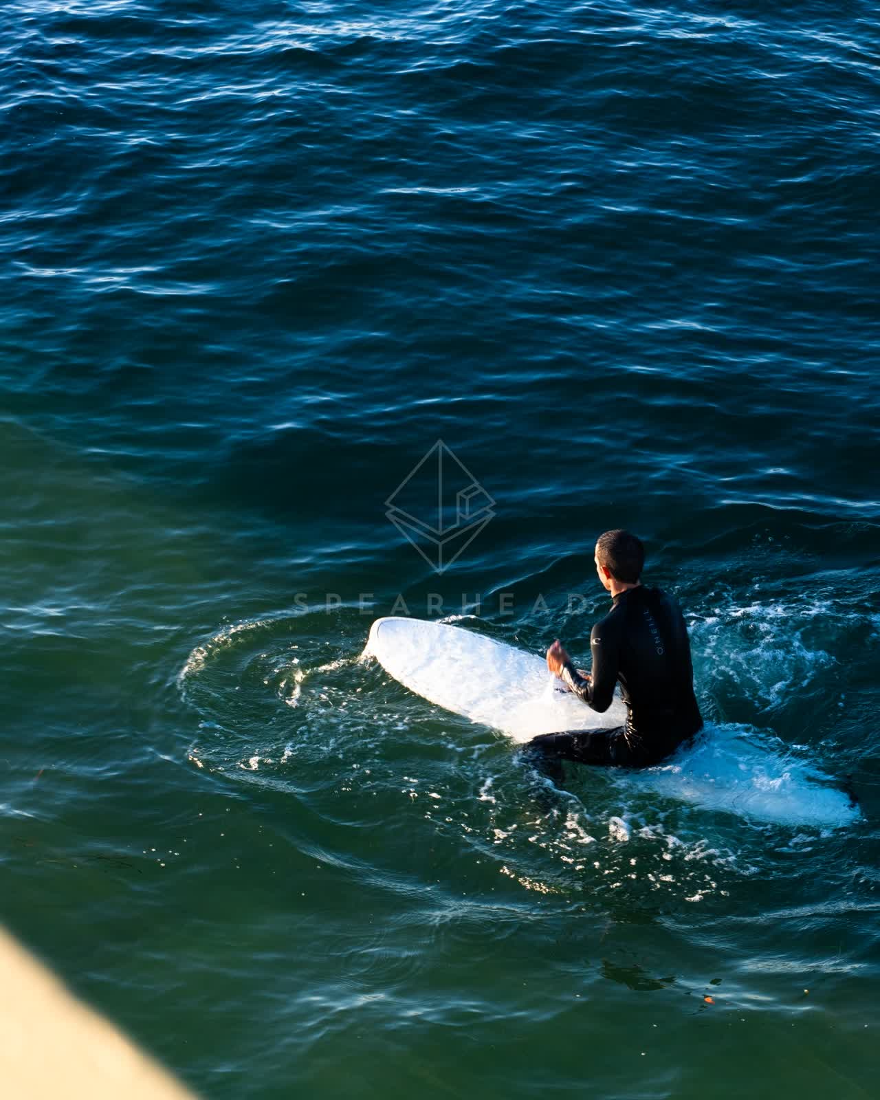 Elevated view of the beach, the surf and the ocean in Ocean Beach, with surfers out.