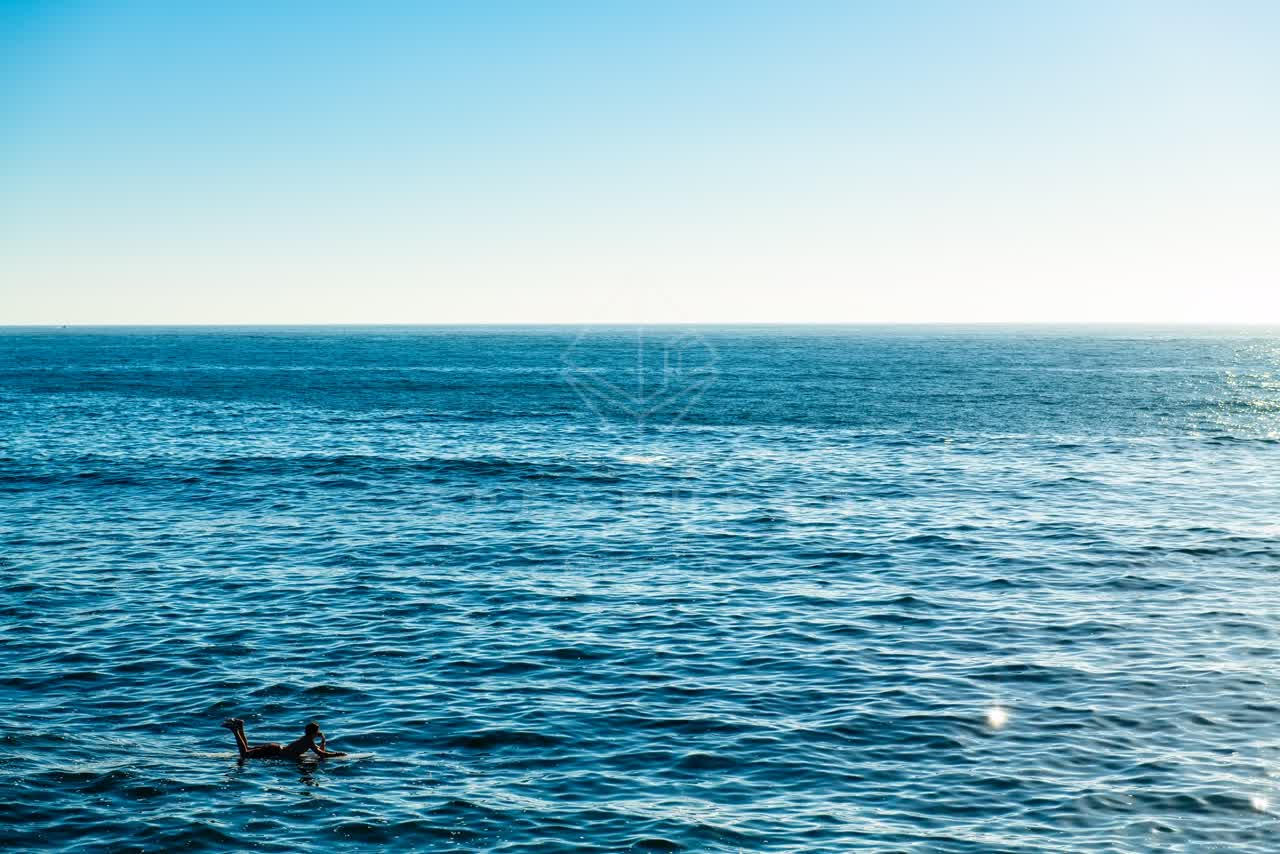 The beach, the surf and the ocean in Ocean Beach, with surfers out.