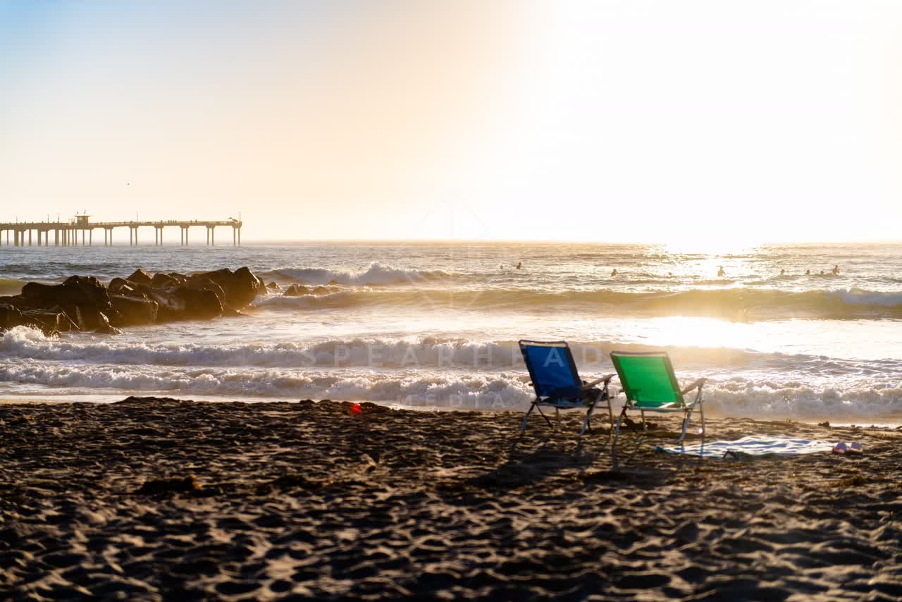 The beach, the surf and the pier in Ocean Beach, with swimmers in the water.