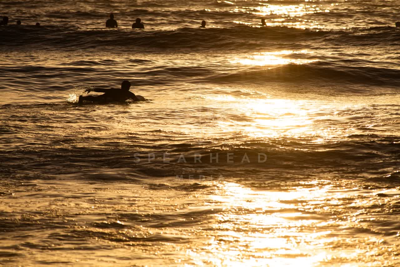 View from the water of the beach, the surf and the ocean in Ocean Beach, with paddlers on the water.