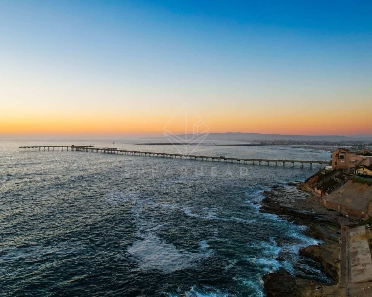 Aerial view of the cliffs, the surf and the pier in Ocean Beach.