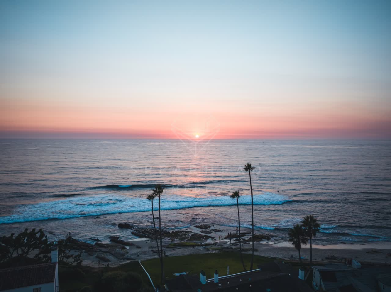 Aerial view of the beach, the surf and palm trees at Windansea.