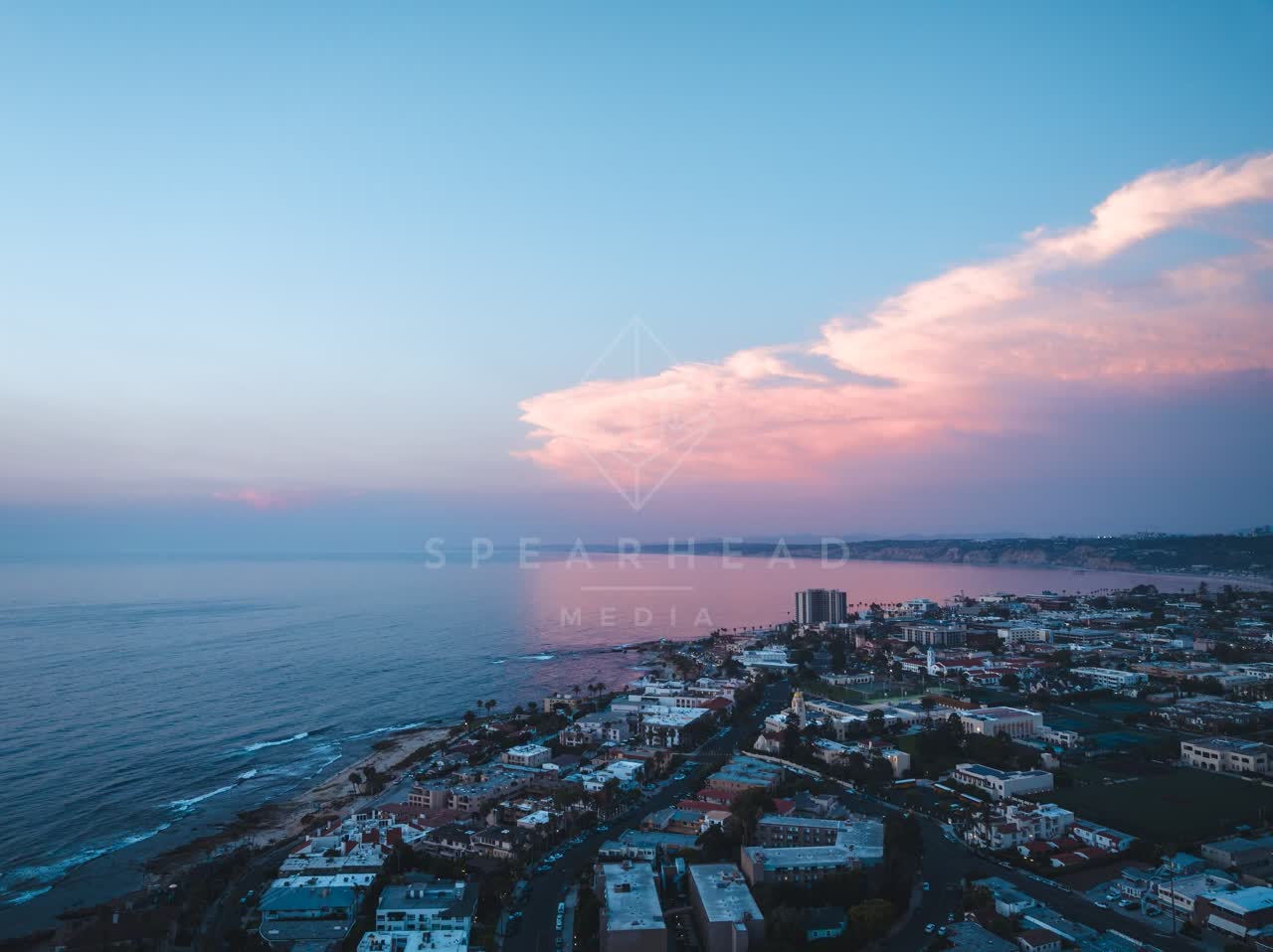Aerial view of a residential street, the ocean and homes at Village of La Jolla.
