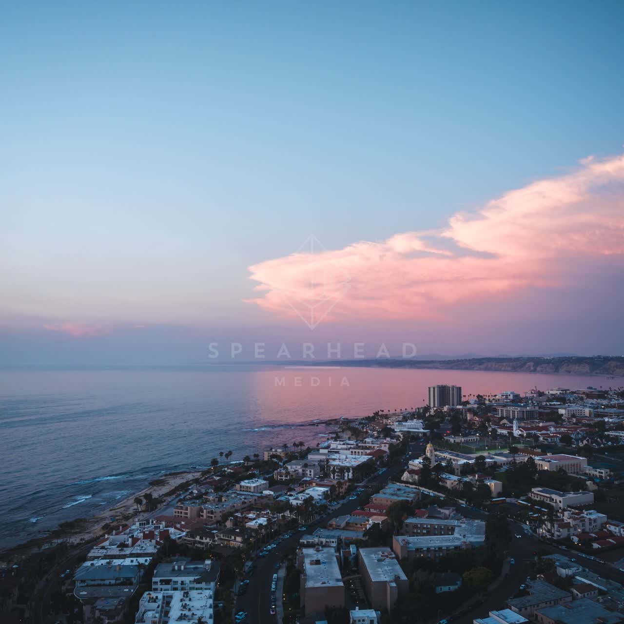 Aerial view of a residential street, palm trees and the ocean at Village of La Jolla.