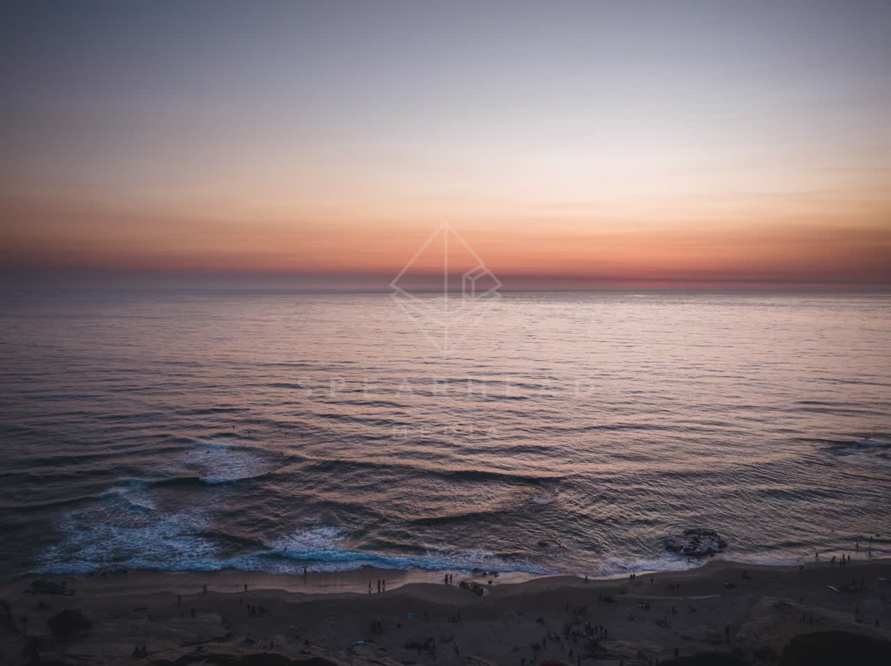 Aerial view of the beach, the surf and the ocean at Windansea, with people walking.