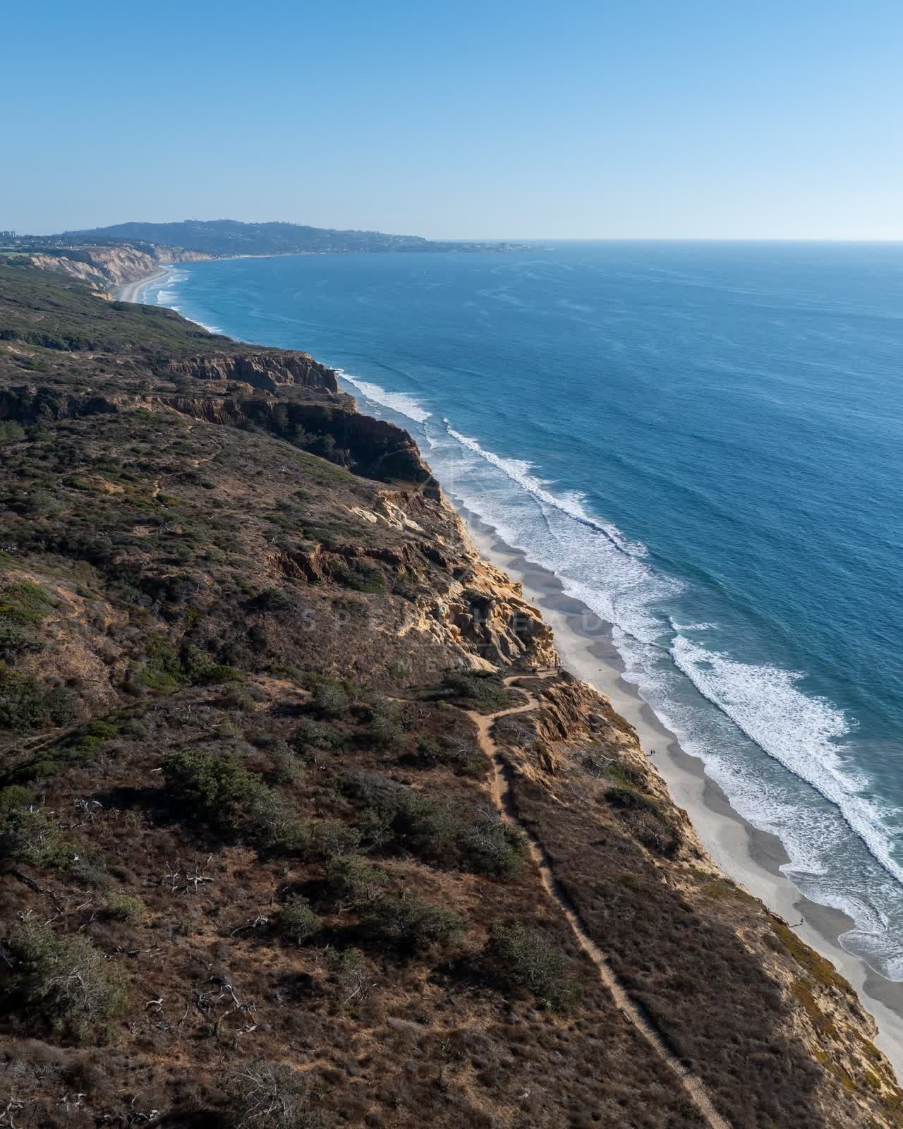 Aerial view of the cliffs, the surf and the ocean at Torrey Pines.
