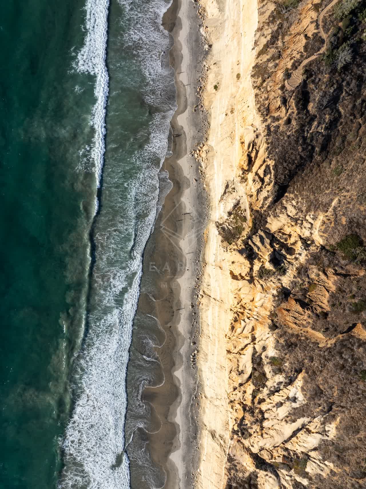 Aerial view of the cliffs, the surf and the ocean at Torrey Pines.