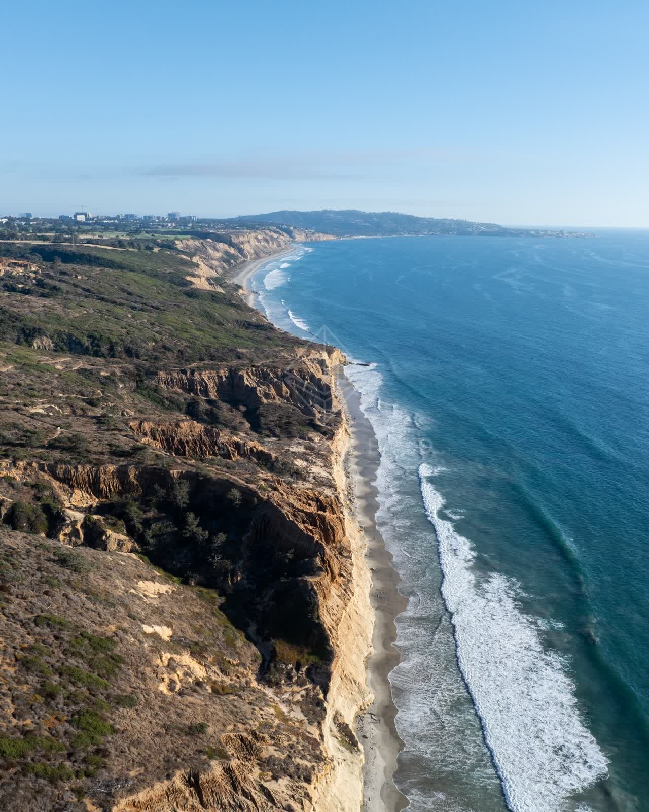 Aerial view of the cliffs, the surf and the ocean at Torrey Pines.