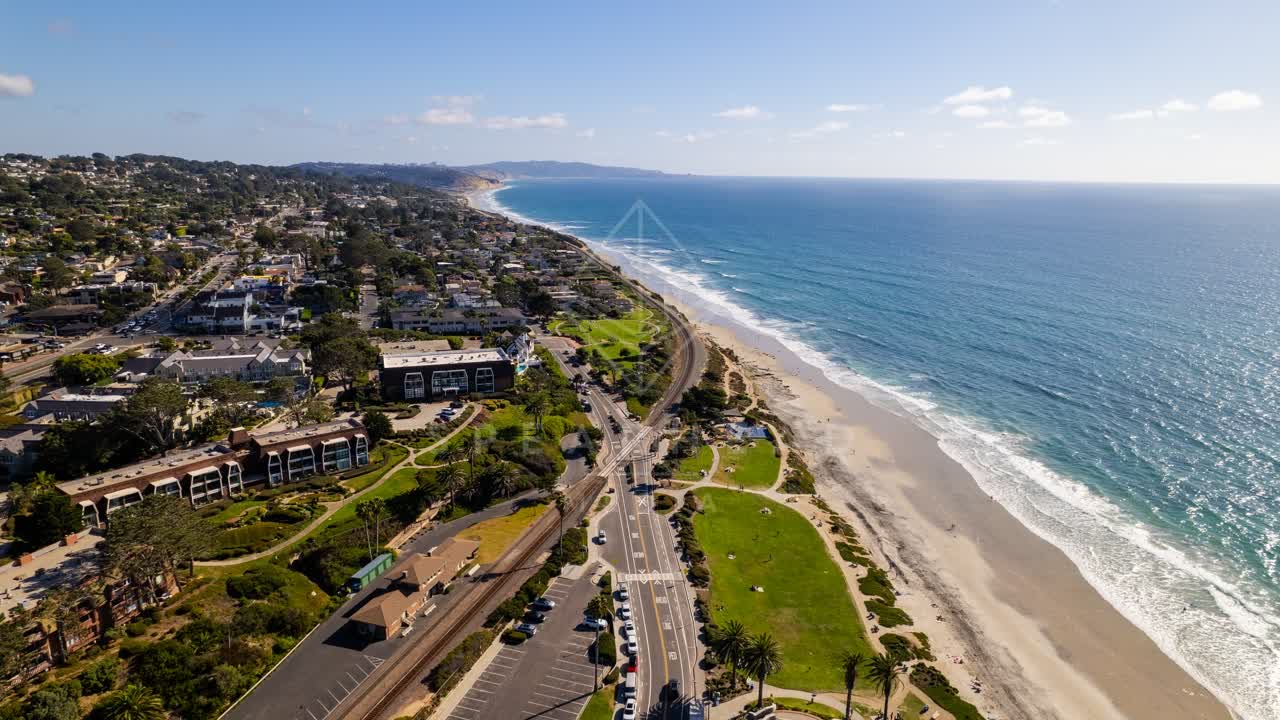 Aerial view of the beach, the surf and palm trees at Powerhouse Park.