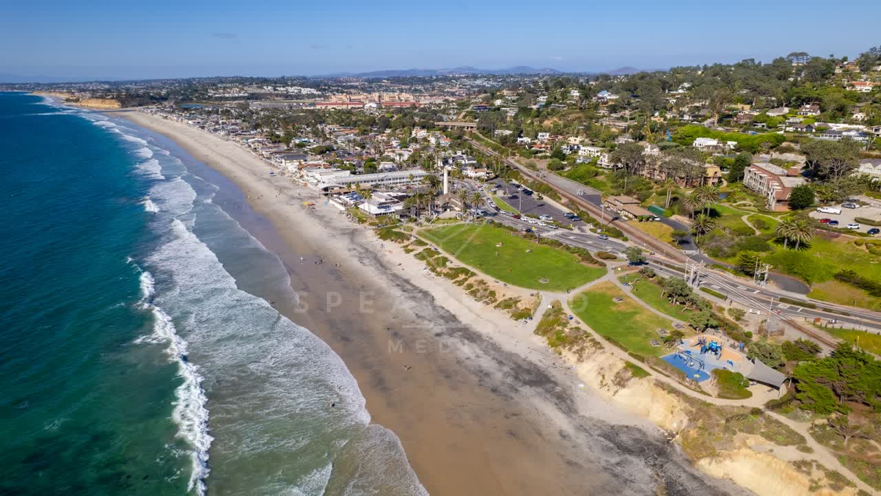 Aerial view of the beach, the surf and palm trees at Powerhouse Park.