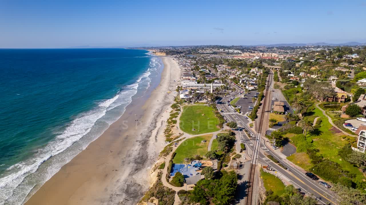 Aerial view of the beach, the surf and palm trees at Powerhouse Park.
