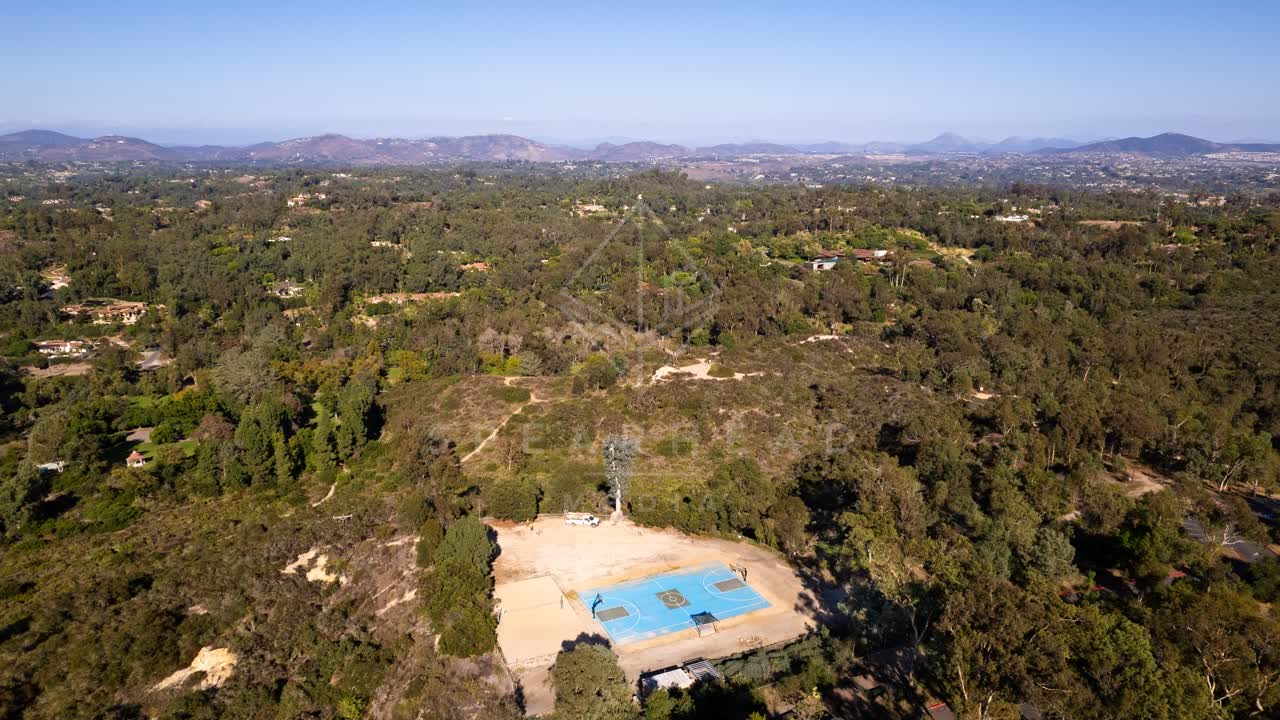 Aerial view of the country inland, open country and the water in Solana Beach, with swimmers in the water.