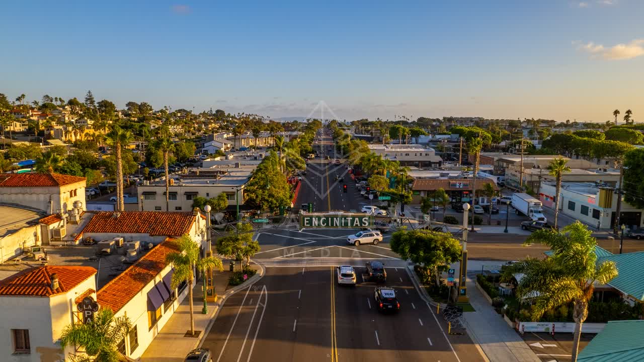 Low aerial view of the downtown streets, palm trees and homes at Downtown Encinitas.