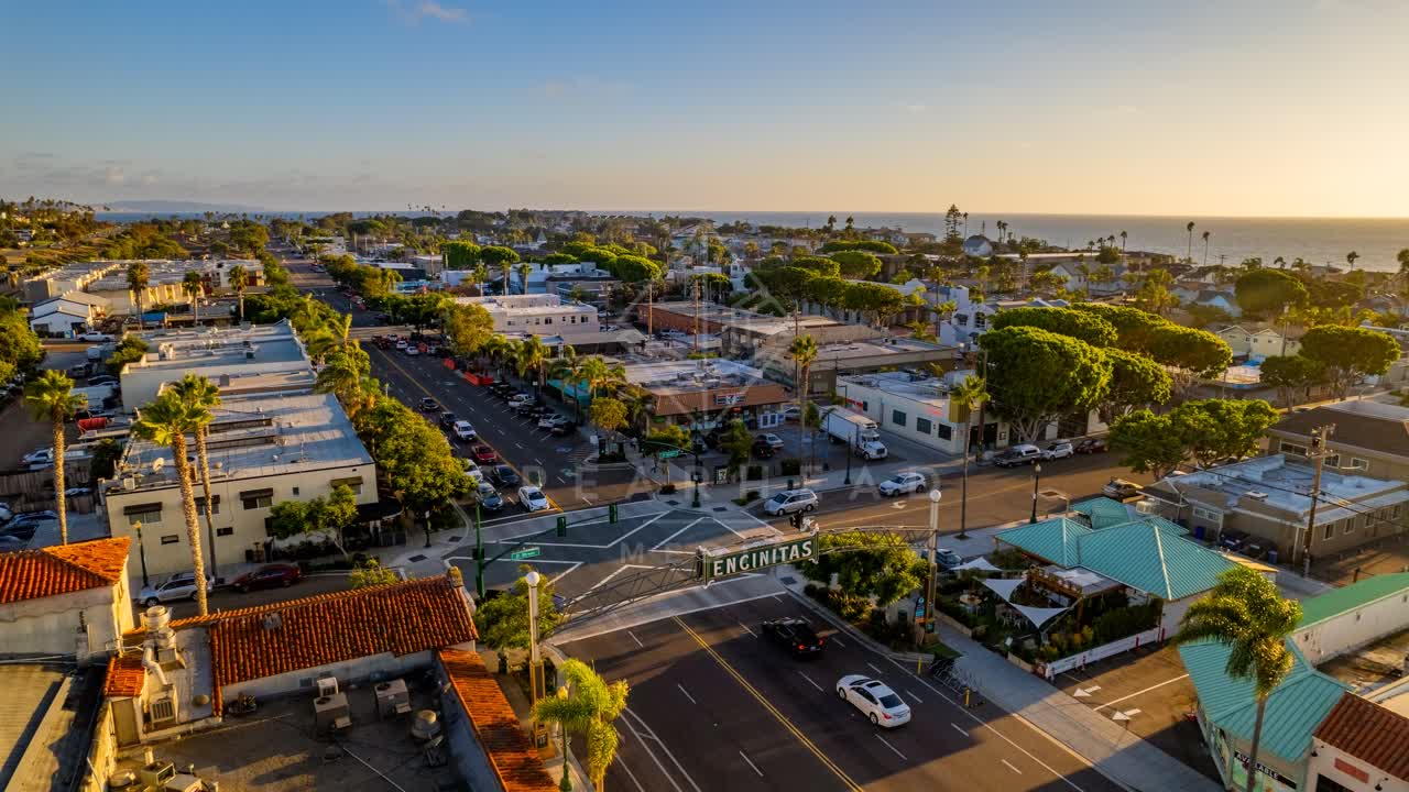 Aerial view of the downtown streets, palm trees and the ocean at Downtown Encinitas, with people walking.