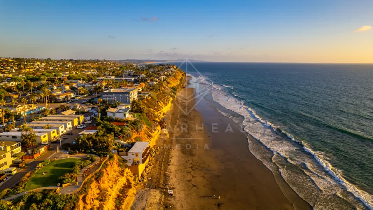 Aerial view of the cliffs, the surf and palm trees in Encinitas.