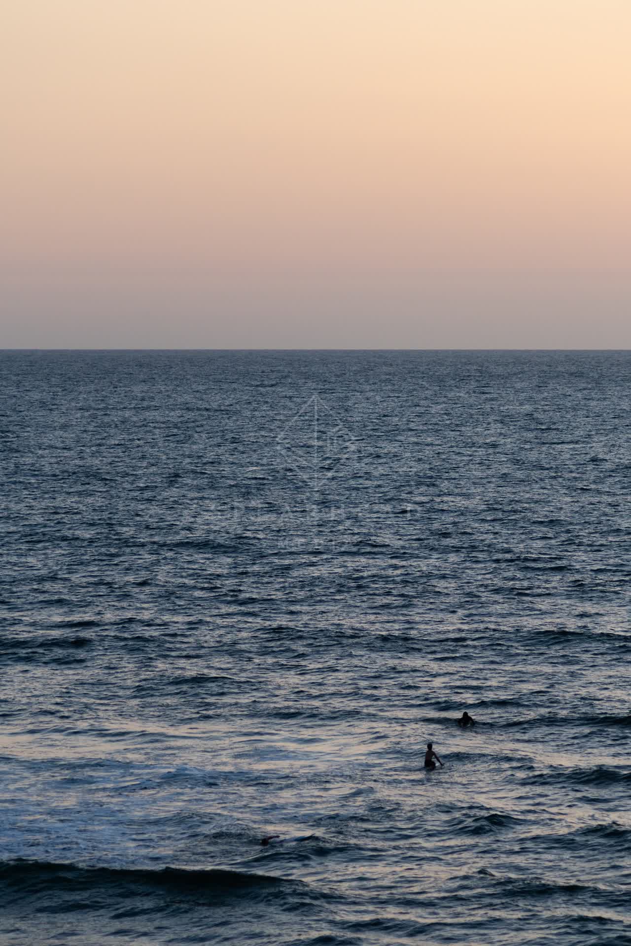 The beach, the surf and the ocean in Encinitas, with swimmers in the water.