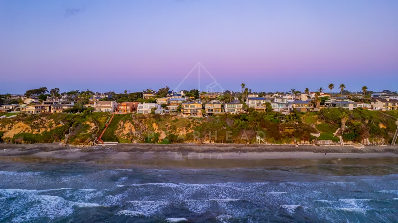 Aerial view of the cliffs, the surf and palm trees in Encinitas.