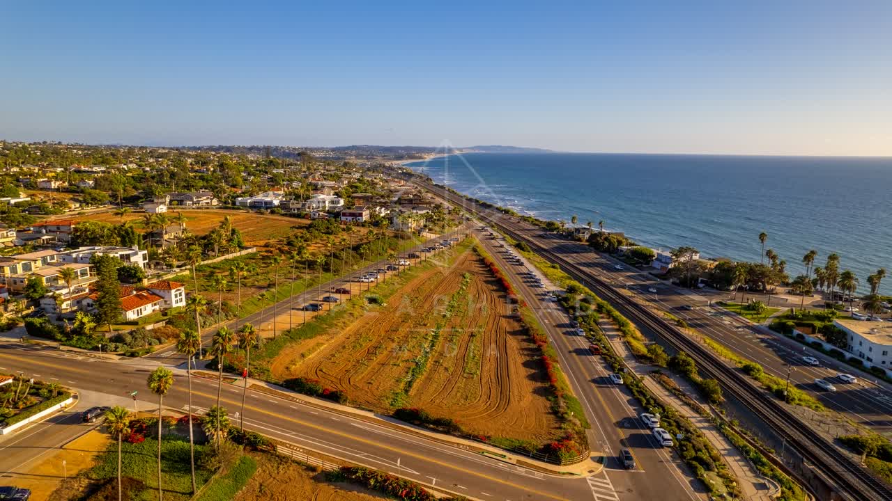 Aerial view of a residential street, palm trees and the ocean at Swamis.