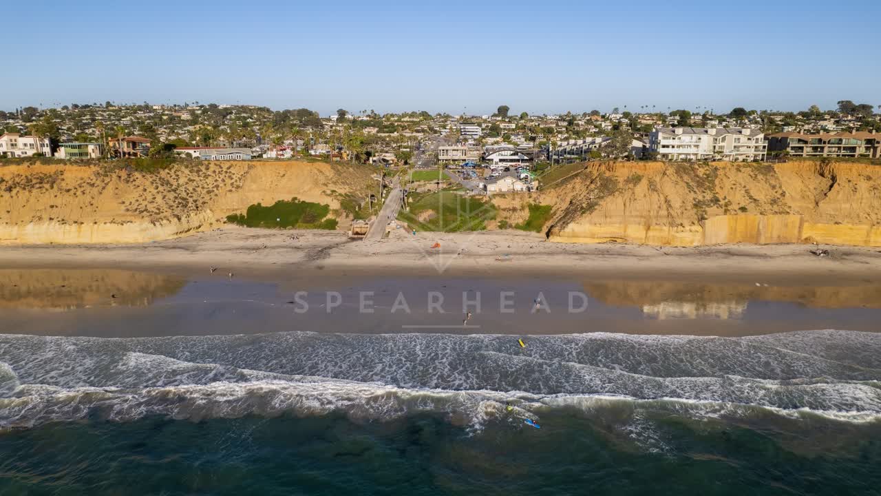 Aerial view of the beach, the surf and the ocean at Fletcher Cove, with people walking.
