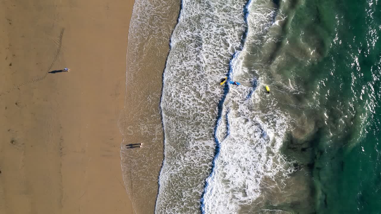 Aerial view of the beach, the surf and the ocean at Fletcher Cove, with swimmers in the water.