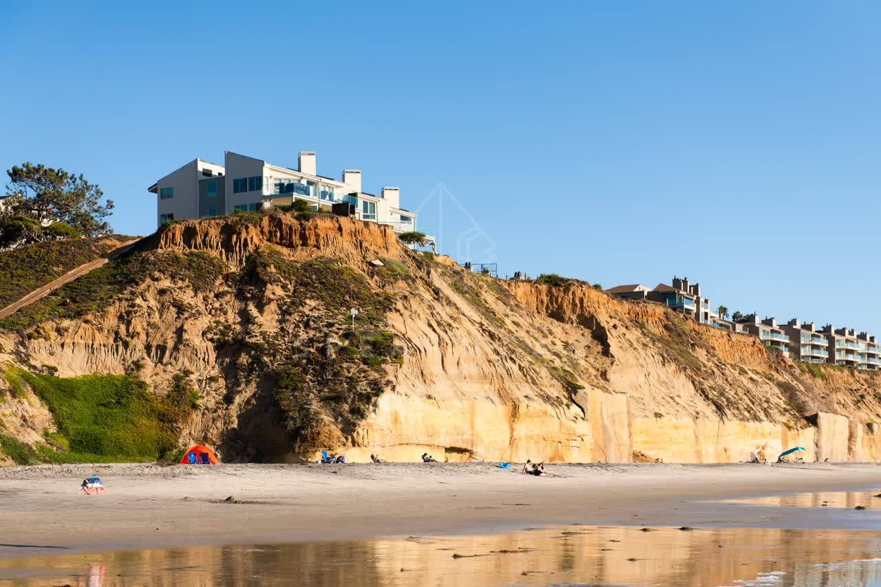 The beach, homes and the buildings at Fletcher Cove, with people walking.