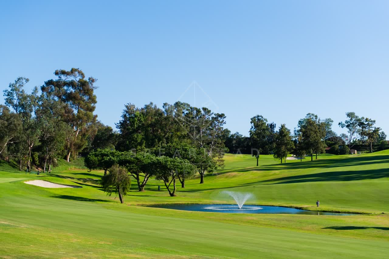 A park, open country and the water in Solana Beach, with people walking.