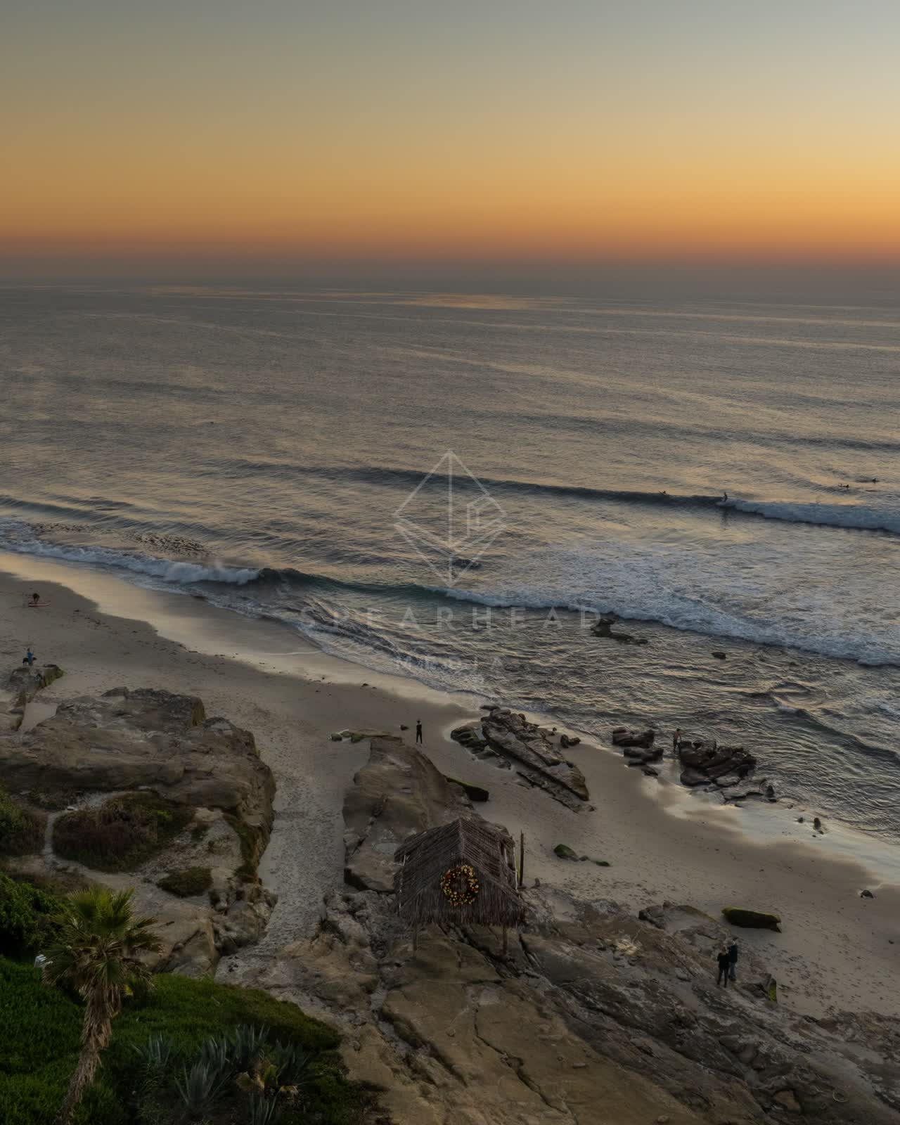 Aerial view of the beach, the surf and the ocean at Windansea, with surfers out.