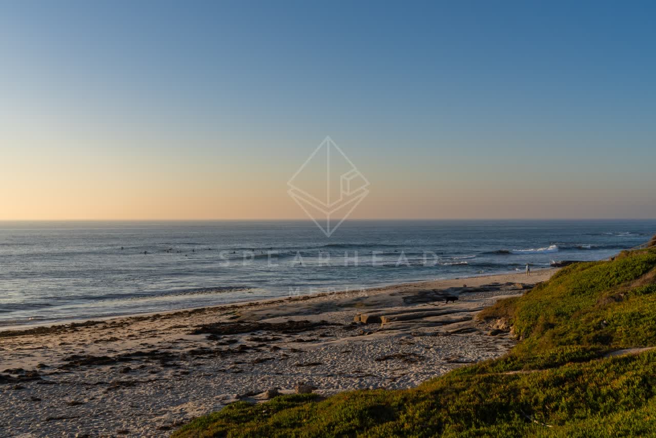 Elevated view of the beach, the surf and the ocean at Windansea, with surfers out.