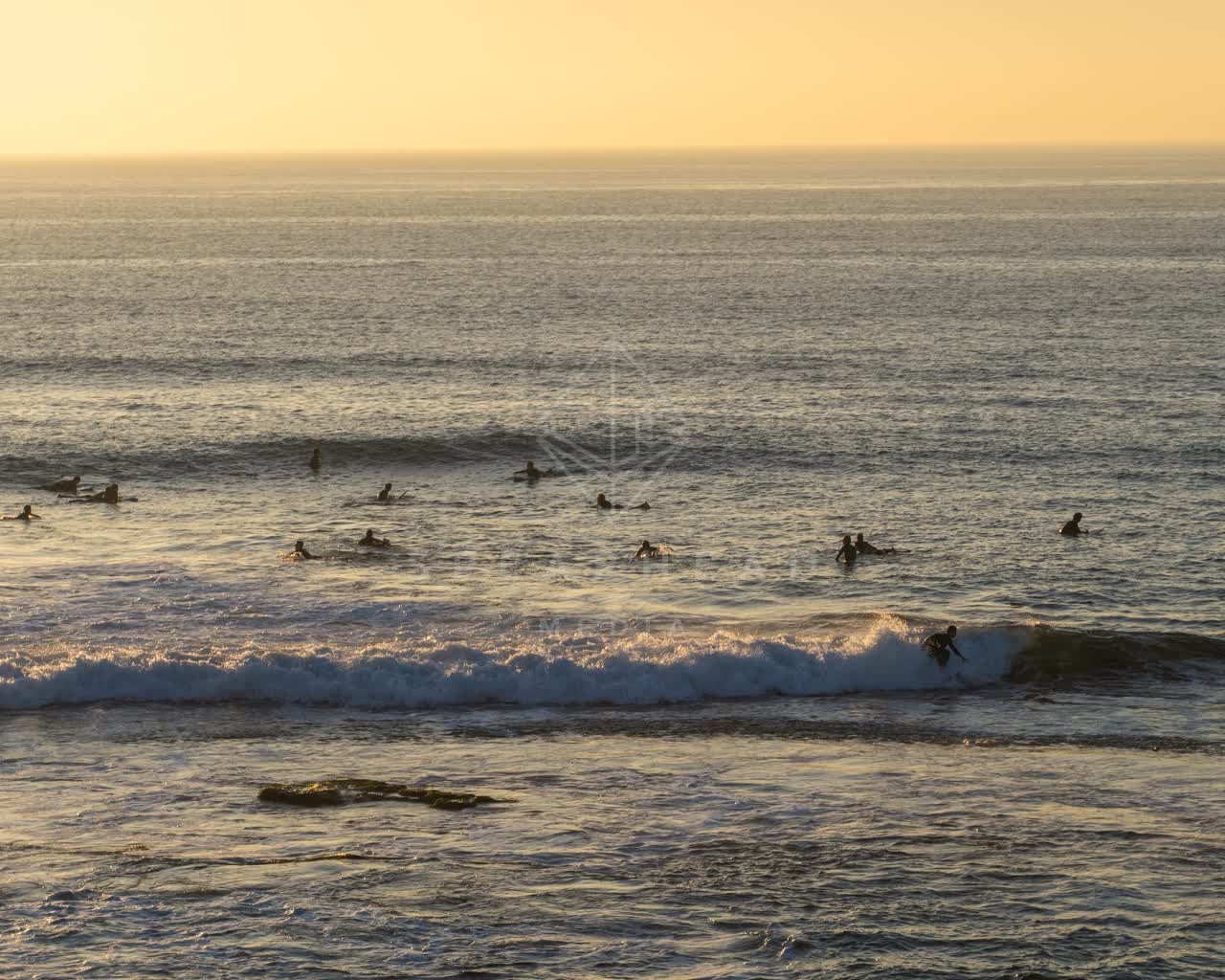 Elevated view of the beach, the surf and the ocean at Windansea, with surfers out.