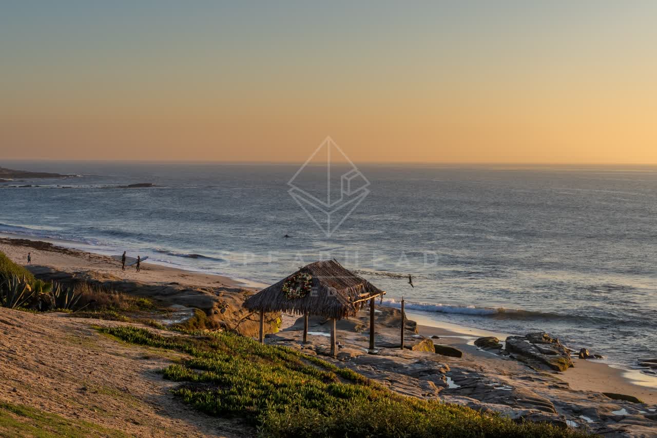 Elevated view of the beach, the surf and the ocean at Windansea, with people walking.