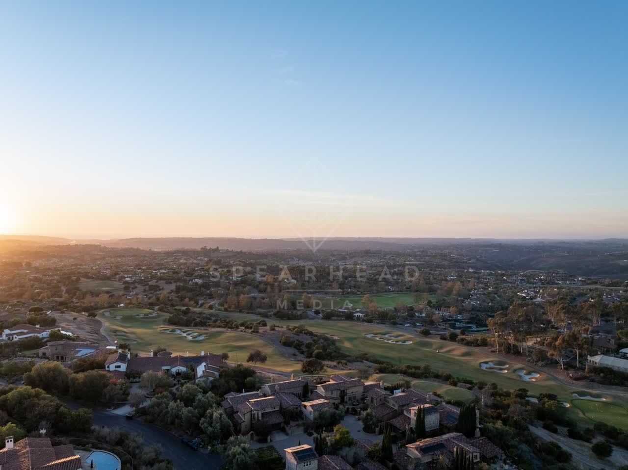 Aerial view of a residential street, homes and open country in Santaluz.